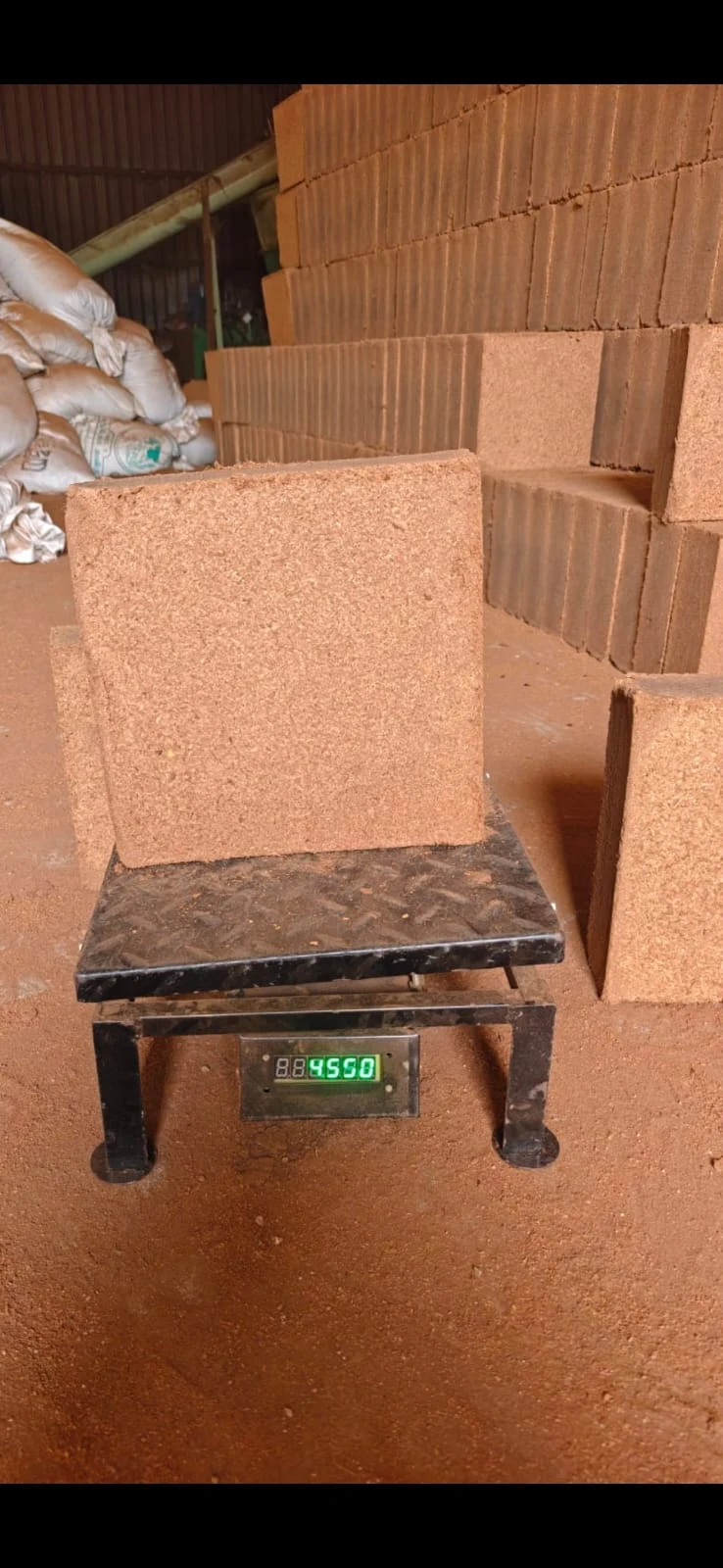 A cocopeat block on a weighing scale at the facility